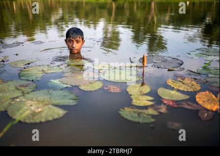 Ein Teenager, der ein Bad in einem Teich auf den Teeplantagen von Sylhet nimmt. Bangladesch. Stockfoto