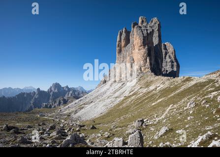 Die drei Zinnen von Osten, links am Fuße der Mauer die Lavaredo Hütte (2344 m), Rifugio Lavaredo, hinter der Cadini Gruppe, Sexten Dolomit Stockfoto