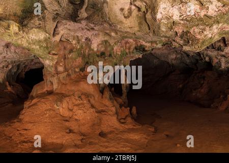 Mehrfarbige Steinsäulen in der Quadiriki-Höhle im Arikok-Nationalpark, Aruba. Farbige Steinwände und -Decke; offene Höhle im Hintergrund. Stockfoto