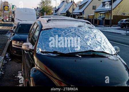Windschutzscheibe eines geparkten Autos, die im Winter mit Schutzfolie bedeckt ist Stockfoto