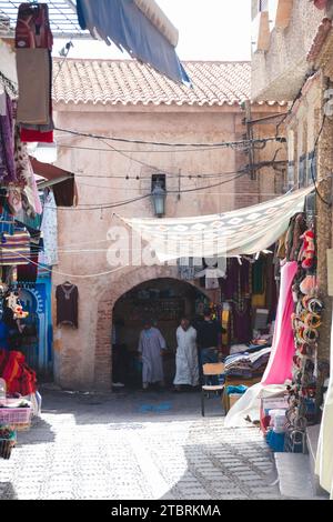 Chefchaouen, Marokko. Oktober 2022 - eines der alten mittelalterlichen Tore der Medina mit Geschäften in einer engen Straße Stockfoto