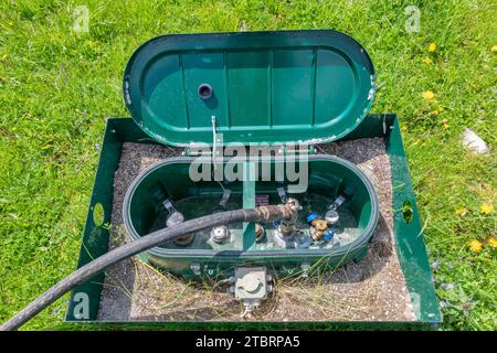 Betankung von LPG-Gas in einem unterirdischen Tank an einer Anlage in einer alpinen Umgebung Stockfoto