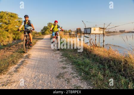 Italien, Emilia Romagna, Viertel Ferrara, Parco del Delta del Po, Comacchio, Radfahrer entlang des Radweges des Valli di Comacchio Stockfoto