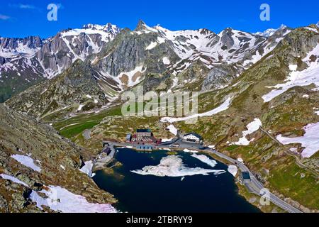 Schmelzender Schnee im Frühling am Bergsee Lac du Grand-St-Bernard an der Großen St. Bernardpass mit Blick über die italienischen Alpen bis zum hoch aufragenden Gipfel Pain de Sucre in Italien, Bourg-Saint-Bernard, Wallis, Schweiz Stockfoto