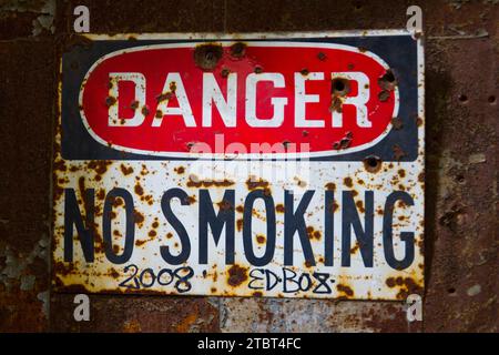 "Rosty Danger No Smoking"-Schild im verlassenen Werk in Illinois Stockfoto