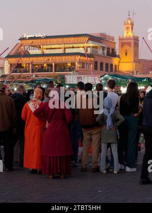 Marktplatz Jemaa el-Fnaa bei Nacht voller Menschenmassen mit goldenem Restaurant in der Stadt Marrakesch aka Marrakesch, Marokko, 08. Dezember 2023 Stockfoto