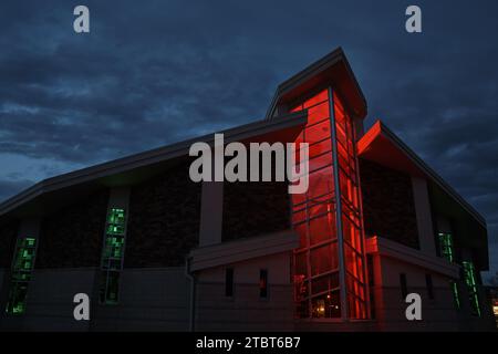 Twilight Glow on Modern Glass Church mit roter und grüner Beleuchtung Stockfoto