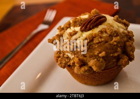 Nahaufnahme des mattierten Gourmet-Apfel-Käsekuchen-Muffins mit Pecan auf weißer Platte Stockfoto