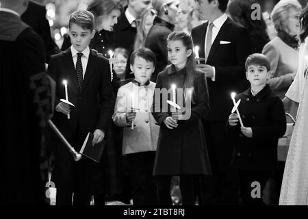 REDAKTEURE BITTE BEACHTEN SIE, DASS DIESES BILD IN SCHWARZ-WEISS UMGEWANDELT WURDE. Prinz George, Christopher Woolf, Prinzessin Charlotte und Prinz Louis halten während der Royal Carols Kerzen – zusammen bei Weihnachtsfeiern in der Westminster Abbey in London. Bilddatum: Freitag, 8. Dezember 2023. Stockfoto