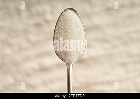 Kollagenpulver auf einem Metalllöffel, Draufsicht Stockfoto