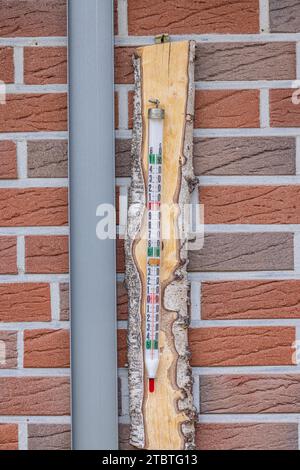 Altes Quecksilberthermometer in einem Holzhalter an einer Hauswand Stockfoto