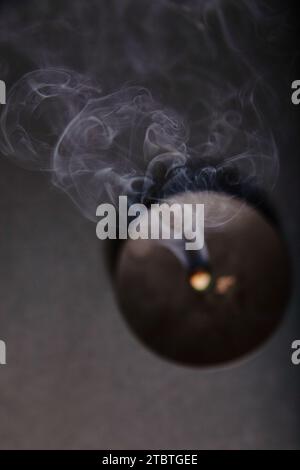 Ätherischer Rauchtanz aus der erloschenen Kerze in ruhigem Dim Light Stockfoto