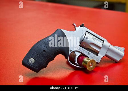 Nahaufnahme des geladenen .22 Magnum Revolvers auf roter Oberfläche Stockfoto