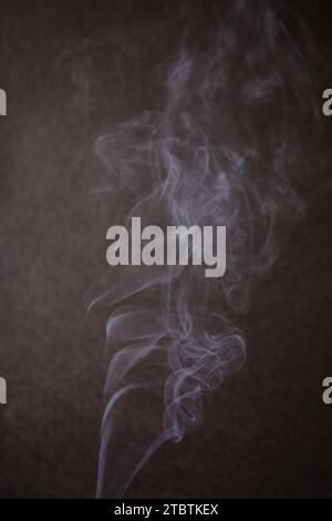 Abstrakter Rauchtanz vor dunklem strukturiertem Hintergrund Stockfoto