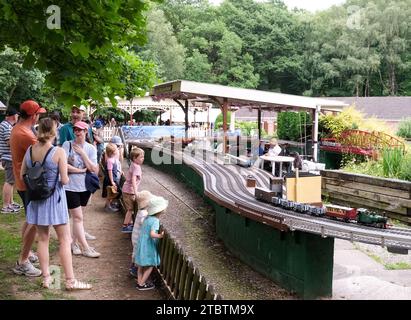 Kinder und ihre Eltern genießen die Modelleisenbahn auf dem Gelände der Abbeydale Miniature Railway Stockfoto