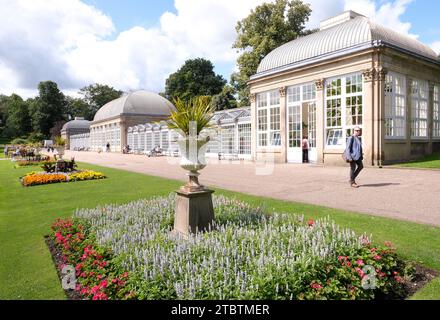 Das Glashaus in Sheffields botanischen Gärten mit einem Gentleman, der vorbeikommt. Stockfoto