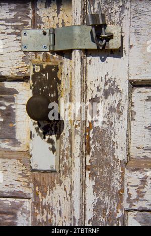 Alte Holztür mit Rusty Vorhängeschloss und Scharnier in Auburn, Indiana Stockfoto