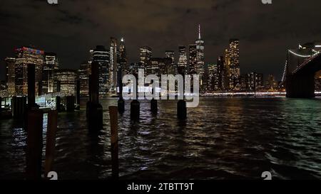 New York City, NY: November 1,2023: Nächtlicher Blick auf die Skyline von Manhattan, aufgenommen von der anderen Seite des Hudson River aus dem Brooklyn Bridge Park Stockfoto