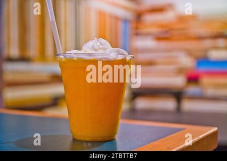 Erfrischendes Eisgetränk mit Schlagsahne in zwangloser Café-Umgebung aus nächster Nähe Stockfoto