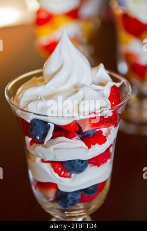 Nahaufnahme des Desserts mit mehrschichtiger Beere und Creme in warmem natürlichem Licht Stockfoto
