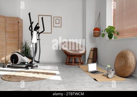 Innenraum des Wohnzimmers mit Sportgeräten und Sessel Stockfoto