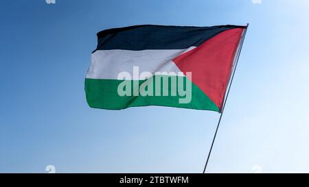 Schwenken der palästinensischen Flagge als Geste der Solidarität während eines Protestes, um die Unterstützung der Bewohner von Gaza zum Ausdruck zu bringen. Stockfoto