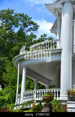 Wunderschönes Vorkriegshaus hat kaputtes Geländer auf dem Geländer auf dem Balkon im zweiten Stock. Elegante runde Veranda mit Holzspindeln. Stockfoto