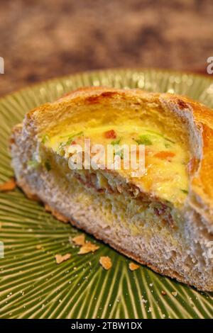 Frisch gebackene Quiche Slice on Green Plate Nahaufnahme Stockfoto