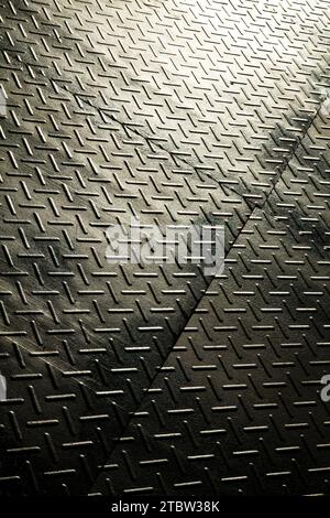 Industrielle Diamantplatte Metallstruktur mit Licht- und Schattenspiel in Nahaufnahme Stockfoto