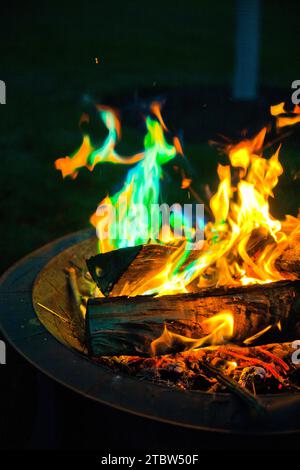 Lebendiges, farbenfrohes Lagerfeuer mit grünen Flammen - Eine Nahaufnahme aus der Perspektive der Nacht Stockfoto