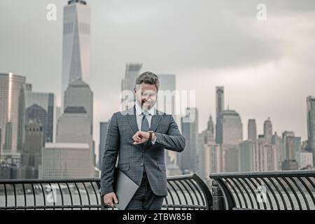 Geschäftsmann, der darauf achtet, Zeit für die Organisation von Unternehmen zu verwalten. Geschäftsmann im Stadtbild in New York. Geschäftsmann im Anzug draußen. Büro Stockfoto