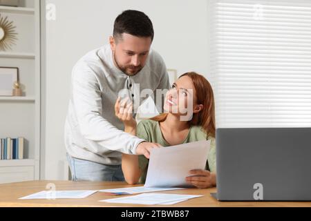 Ein Paar, das Steuern am Tisch im Zimmer macht Stockfoto