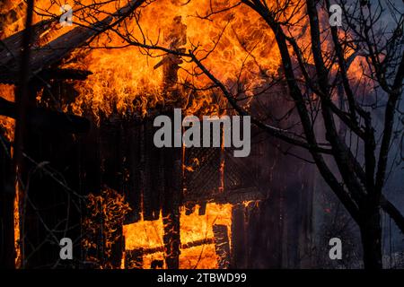 Brennendes Haus in großem Feuer. Brennendes Gebäude. Offenes Feuer. Brennendes Haus. Einfamilienhaus komplett zerstört durch Flammen. Feuer Feuer Flamme Stockfoto