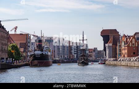 Ein Bild von einigen Wahrzeichen Danzig neben dem Fluss Motlawa, wie dem Kran (rechts), dem Soldek-Schiffsmuseum (links) und dem Schwarzen Perlenschiff Stockfoto