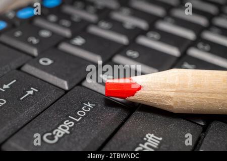 Roter Bleistift auf einer Computertastatur, Nahansicht Stockfoto