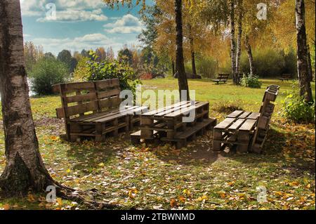 Gartenmöbel aus Holzpaletten stehen im Herbst aus Laubwald Stockfoto