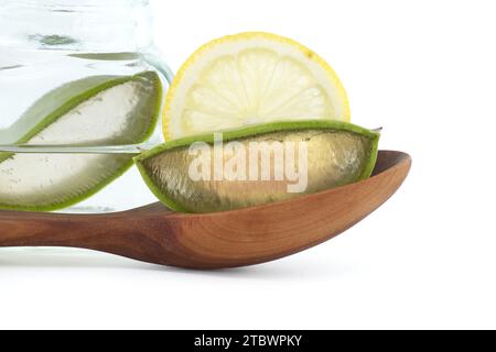 Aloe Vera Blattscheiben in einem Holzlöffel und Zitronenscheiben isoliert auf weißem Hintergrund, natürliche biologische kosmetische Inhaltsstoffe für empfindliche Haut Stockfoto