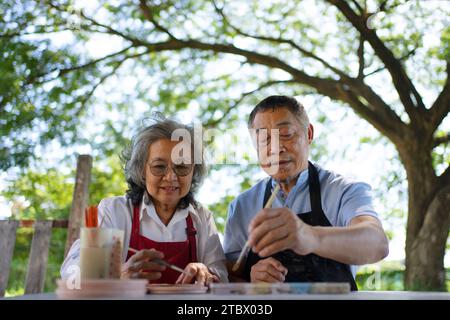 Seniorenpaar lernen, wie man Töpferei macht. Freizeitaktivität und Lifestyle-Konzept. Stockfoto