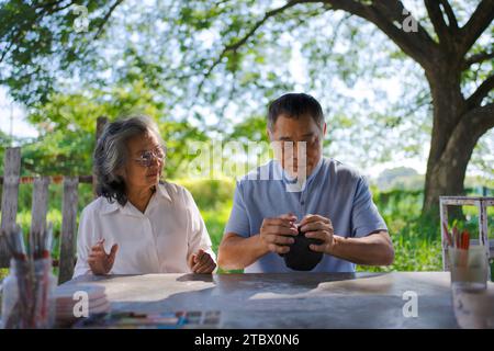 Seniorenpaar lernen, wie man Töpferei macht. Freizeitaktivität und Lifestyle-Konzept. Stockfoto