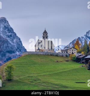 Die Kirche Chiesa Santa Lucia in Colle Santa Lucia am Fuße des Giau-Passes, Passo di Giau, im Herbst. Stockfoto