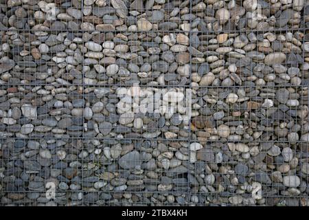 Gabion Gittersteinmauer durch Kieselsteine in Eisenkäfig aus Felsen horizontale Steinkiste gefüllt mit Felsen Hintergrund Stockfoto