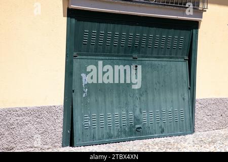 Alte verwitterte und rostige Stahltür geschlossen offene grüne sequentielle Metalltür in der Gebäudefassade Stockfoto