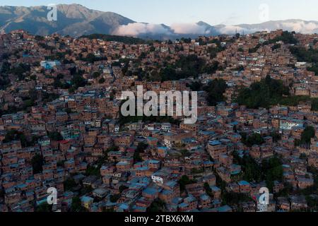 Caracas, Venezuela. November 2023 30. ANMERKUNG DER REDAKTION: Bild mit Drohne aufgenommen) aus der Vogelperspektive des Viertels Petare, eines der ärmsten und gewalttätigsten der Stadt, das bei Sonnenuntergang zu sehen ist. Obwohl die Beschränkungen für den Währungsumtausch gelockert wurden und die meisten Transaktionen jetzt in US-Dollar abgewickelt werden, befindet sich die venezolanische Wirtschaft mit einer jährlichen Inflation von 398 % und einem Rückgang der Wirtschaftstätigkeit um 7 % immer noch in ernsten Schwierigkeiten, bis Ende des Monats zu erreichen. (Foto: Davide Bonaldo/SOPA Images/SIPA USA) Credit: SIPA USA/Alamy Live News Stockfoto