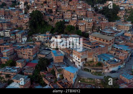 Caracas, Venezuela. November 2023 30. ANMERKUNG DER REDAKTION: Bild mit Drohne aufgenommen) aus der Vogelperspektive des Viertels Petare, eines der ärmsten und gewalttätigsten der Stadt, das bei Sonnenuntergang zu sehen ist. Obwohl die Beschränkungen für den Währungsumtausch gelockert wurden und die meisten Transaktionen jetzt in US-Dollar abgewickelt werden, befindet sich die venezolanische Wirtschaft mit einer jährlichen Inflation von 398 % und einem Rückgang der Wirtschaftstätigkeit um 7 % immer noch in ernsten Schwierigkeiten, bis Ende des Monats zu erreichen. (Foto: Davide Bonaldo/SOPA Images/SIPA USA) Credit: SIPA USA/Alamy Live News Stockfoto