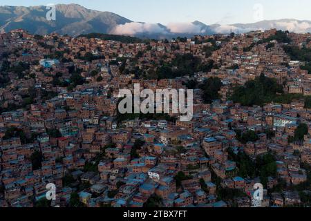 Caracas, Venezuela. November 2023 30. ANMERKUNG DER REDAKTION: Bild mit Drohne aufgenommen) .Luftaufnahme des Viertels Petare, eines der ärmsten und gewalttätigsten der Stadt, gesehen bei Sonnenuntergang. Obwohl die Beschränkungen für den Währungsumtausch gelockert wurden und die meisten Transaktionen jetzt in US-Dollar abgewickelt werden, befindet sich die venezolanische Wirtschaft mit einer jährlichen Inflation von 398 % und einem Rückgang der Wirtschaftstätigkeit um 7 % immer noch in ernsten Schwierigkeiten, bis Ende des Monats zu erreichen. (Credit Image: © Davide Bonaldo/SOPA Images via ZUMA Press Wire) NUR REDAKTIONELLE VERWENDUNG! Nicht für kommerzielle ZWECKE! Stockfoto