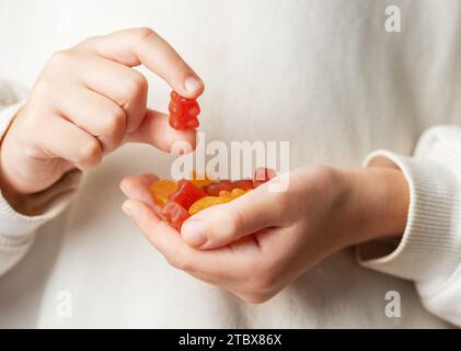 Kaugummibärchen Vitamine und Nahrungsergänzungsmittel. Ein Mädchen hält einen Gummibärenvitamine in den Händen. Stockfoto