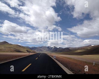 Ein Blick aus der Vogelperspektive auf eine schwarze Asphaltstraße, die durch eine offene Landschaft führt Stockfoto