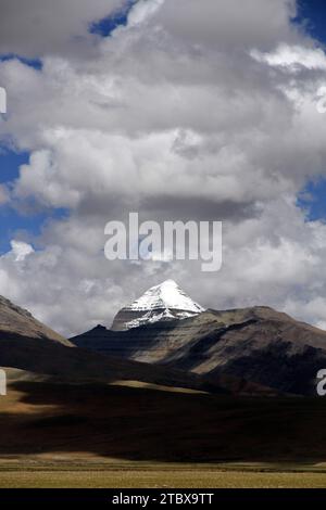 Dieses atemberaubende Foto fängt die unberührte Schönheit der Berge mit einer Himmelskulisse und weißen flauschigen Wolken ein Stockfoto