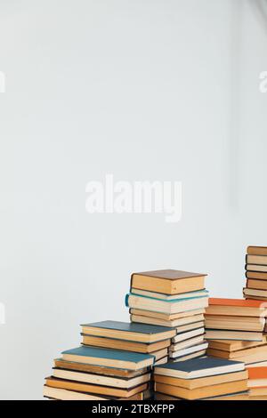 Stapel alter Bücher in der Studierendenbibliothek auf weißem Hintergrund Stockfoto