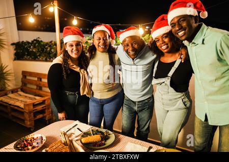 Glückliche afrikanische Familie, die Spaß beim gemeinsamen Essen während der Weihnachtszeit hat - Weihnachtskonzept - Hauptfokus auf Vatergesicht Stockfoto